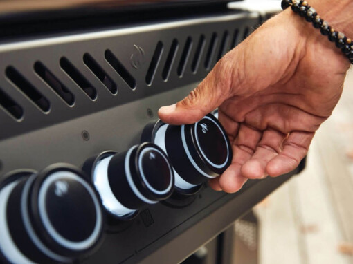 Monsieur qui met sa main sur le bouton du barbecue au gaz