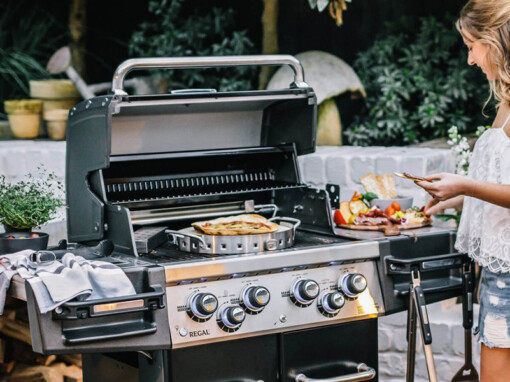 une femme cuit le repas avec le barbecue Broil King