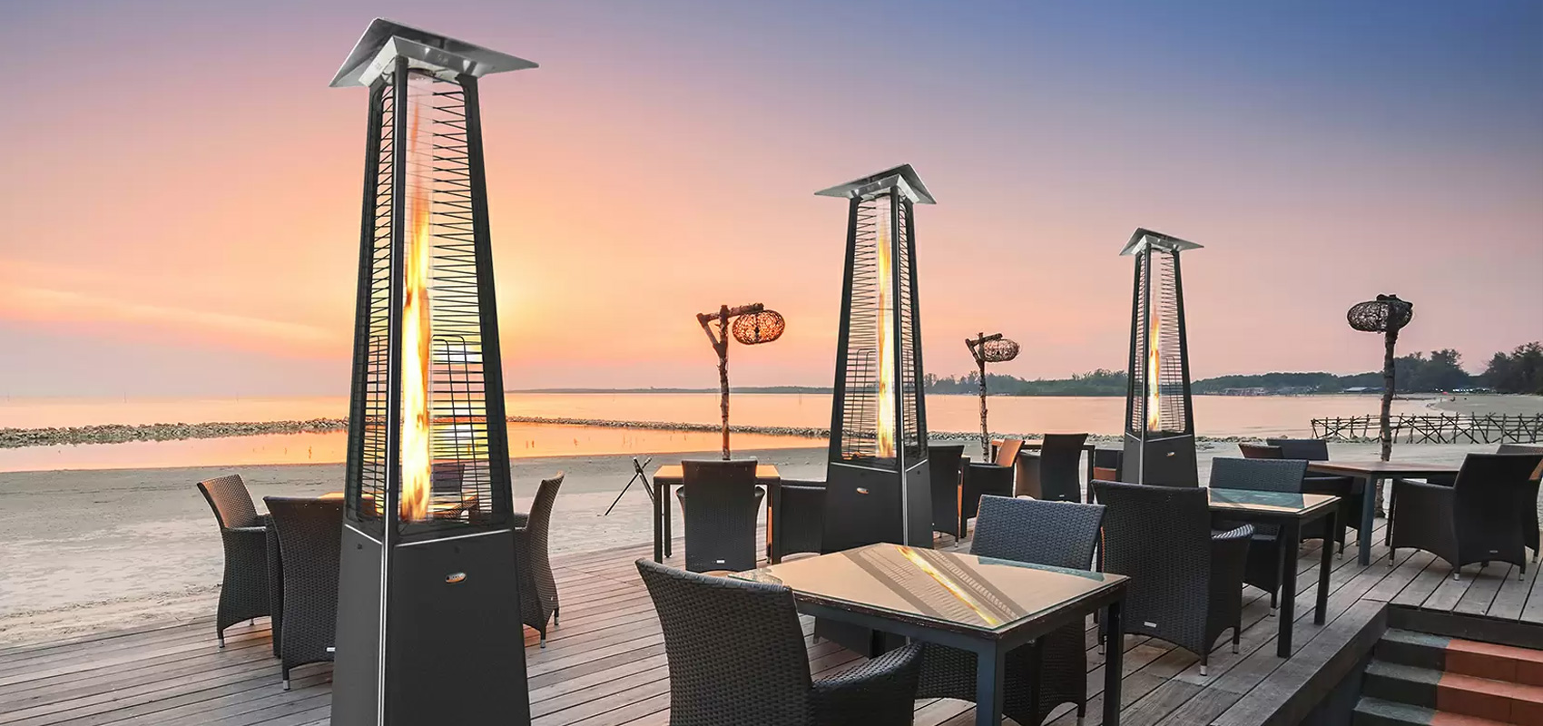 Terrasse d'une plage avec plusieurs lampes de chauffage près des tables